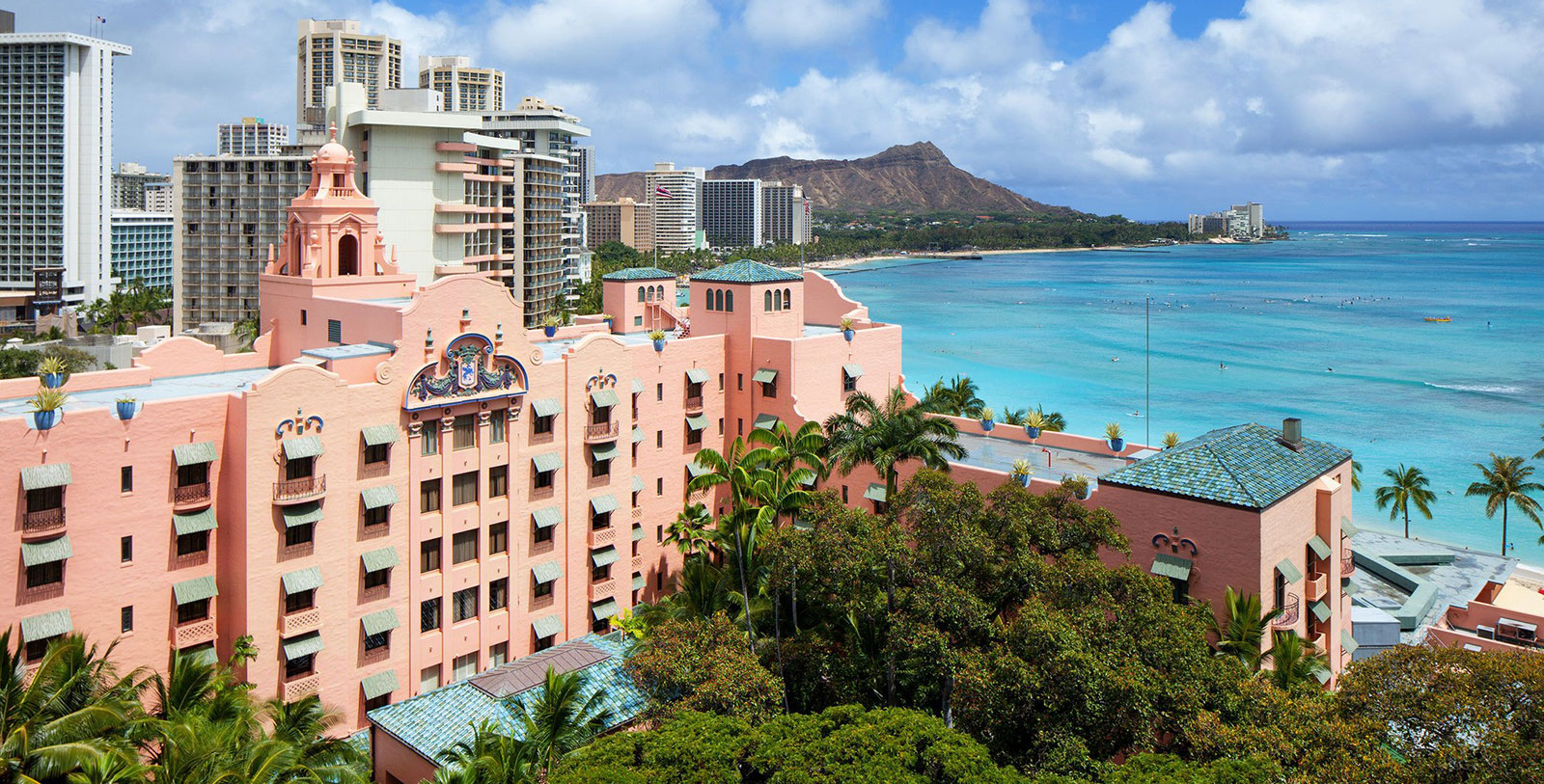 Image of Hotel Exterior and Waikiki, Honolulu cityscape in background, The Royal Hawaiian, A Luxury Collection Resort, 1927, Member of Historic Hotels of America, in Honolulu, Hawaii, Discover